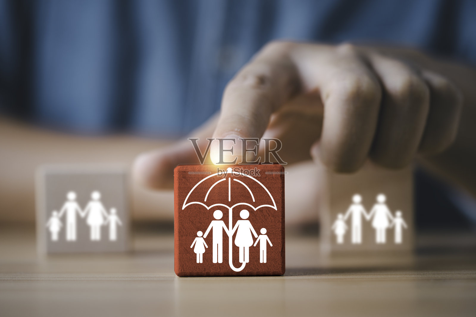 一只手选择带有家庭保护伞符号的木块，代表保险、安全、保障、关怀、支持以及家庭和生活规划的风险管理概念图照片摄影图片