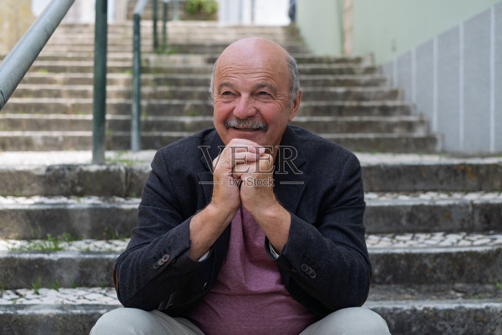一位老人坐在楼梯上休息，回忆着他的青春岁月照片摄影图片