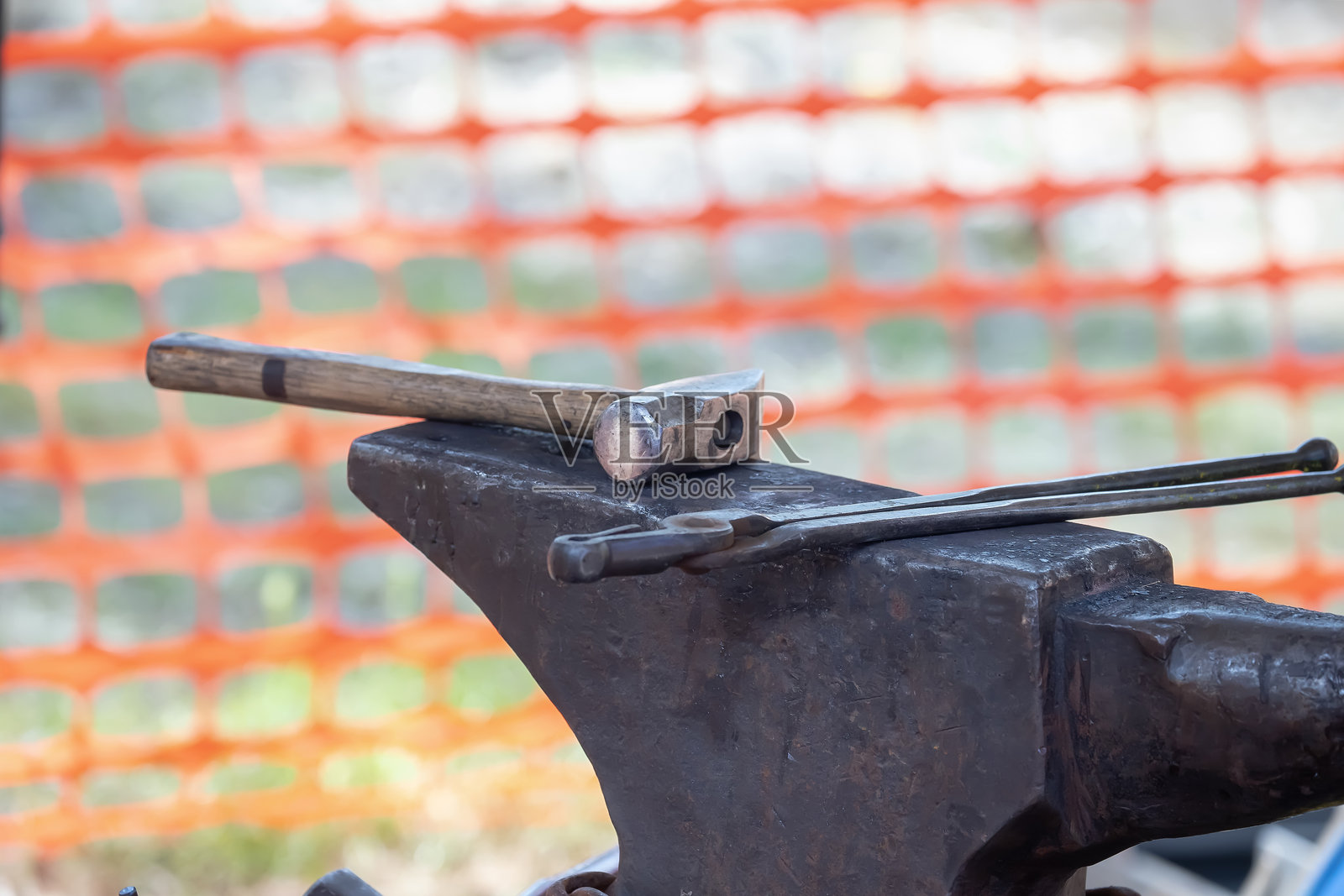 铁匠在户外锻造炉中，使用发光的煤炭和金属工具进行工作照片摄影图片