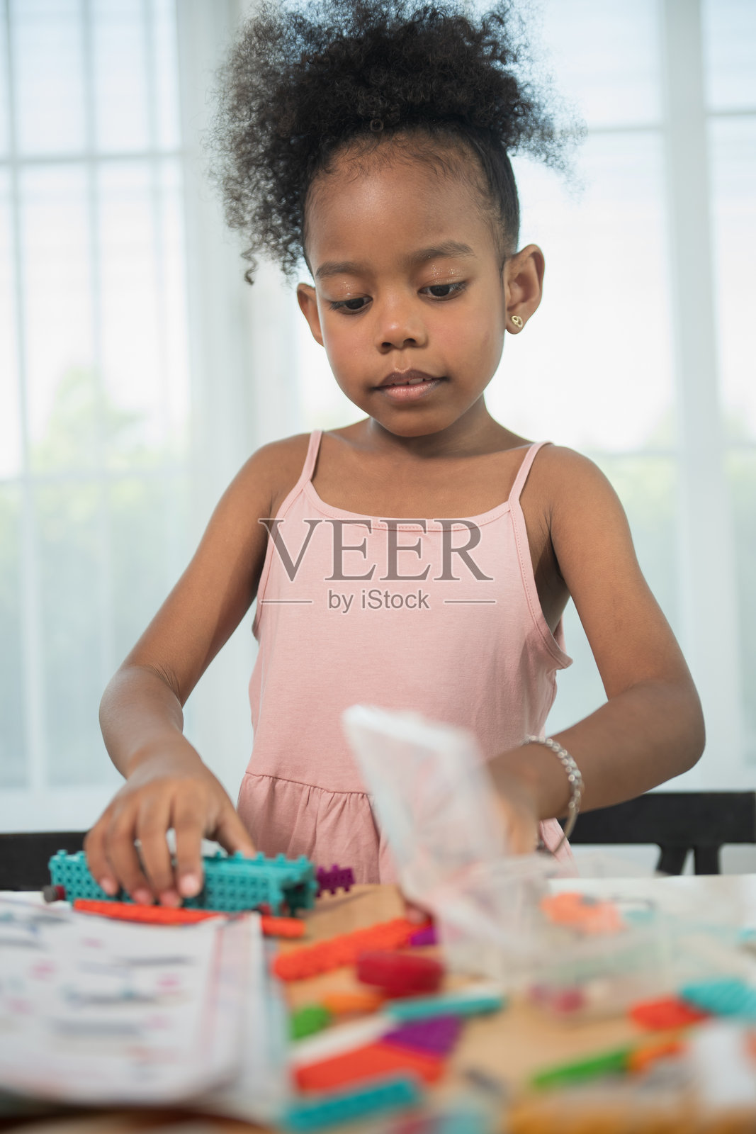 孩子们在桌子上玩积木，孩子用彩色的塑料积木玩耍和搭建。照片摄影图片