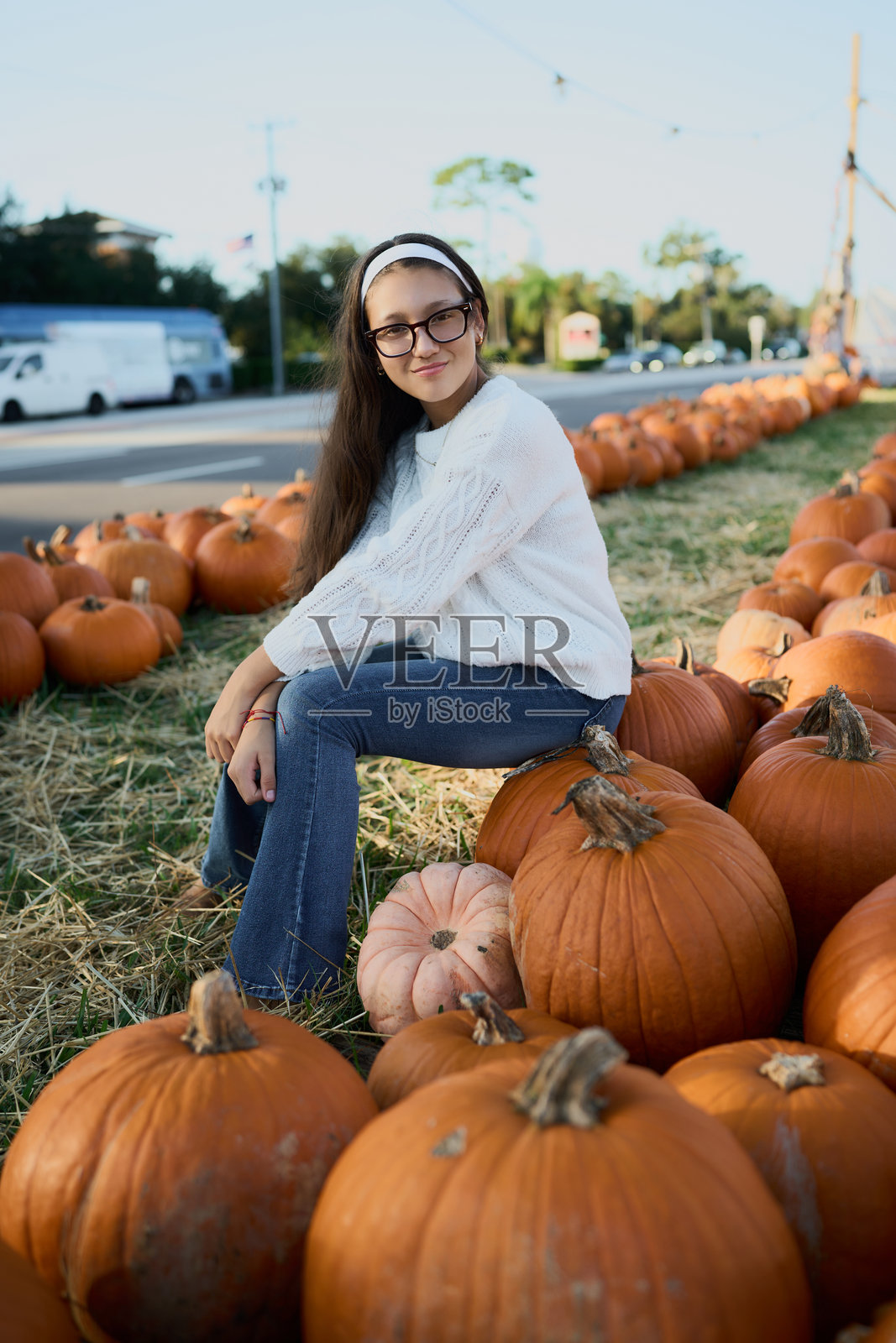 年轻女子坐在户外南瓜地里照片摄影图片