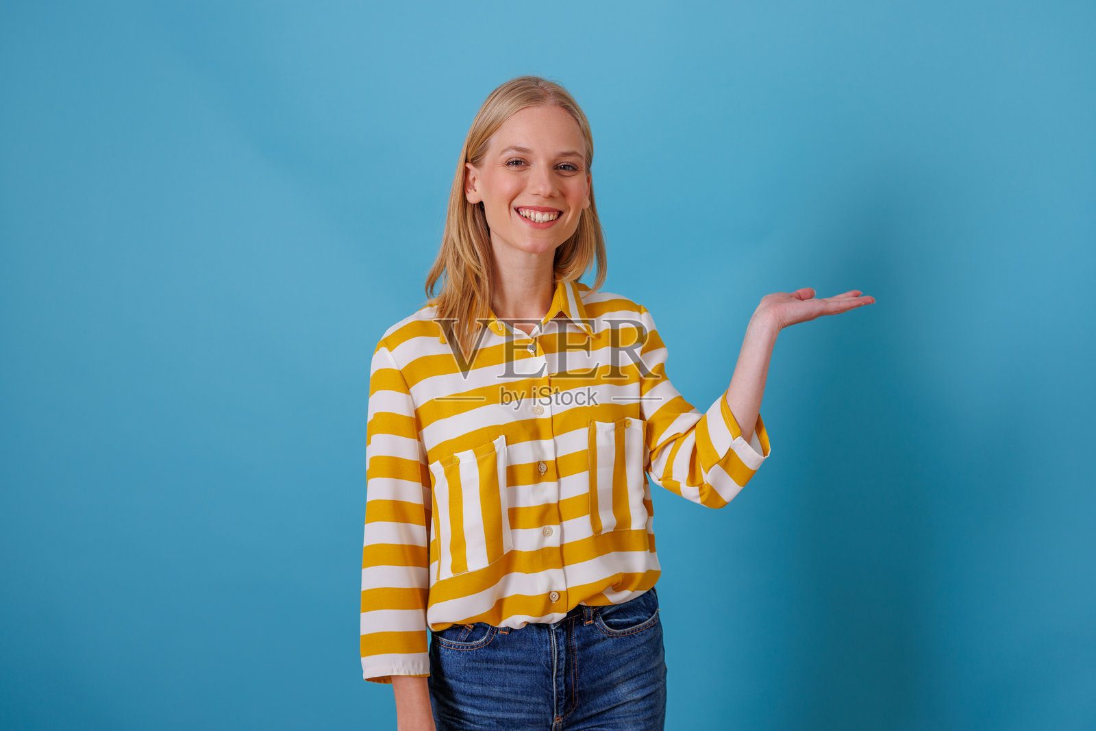 面带微笑的年轻女子伸出空掌，提供或展示着可供复制的空白区域照片摄影图片