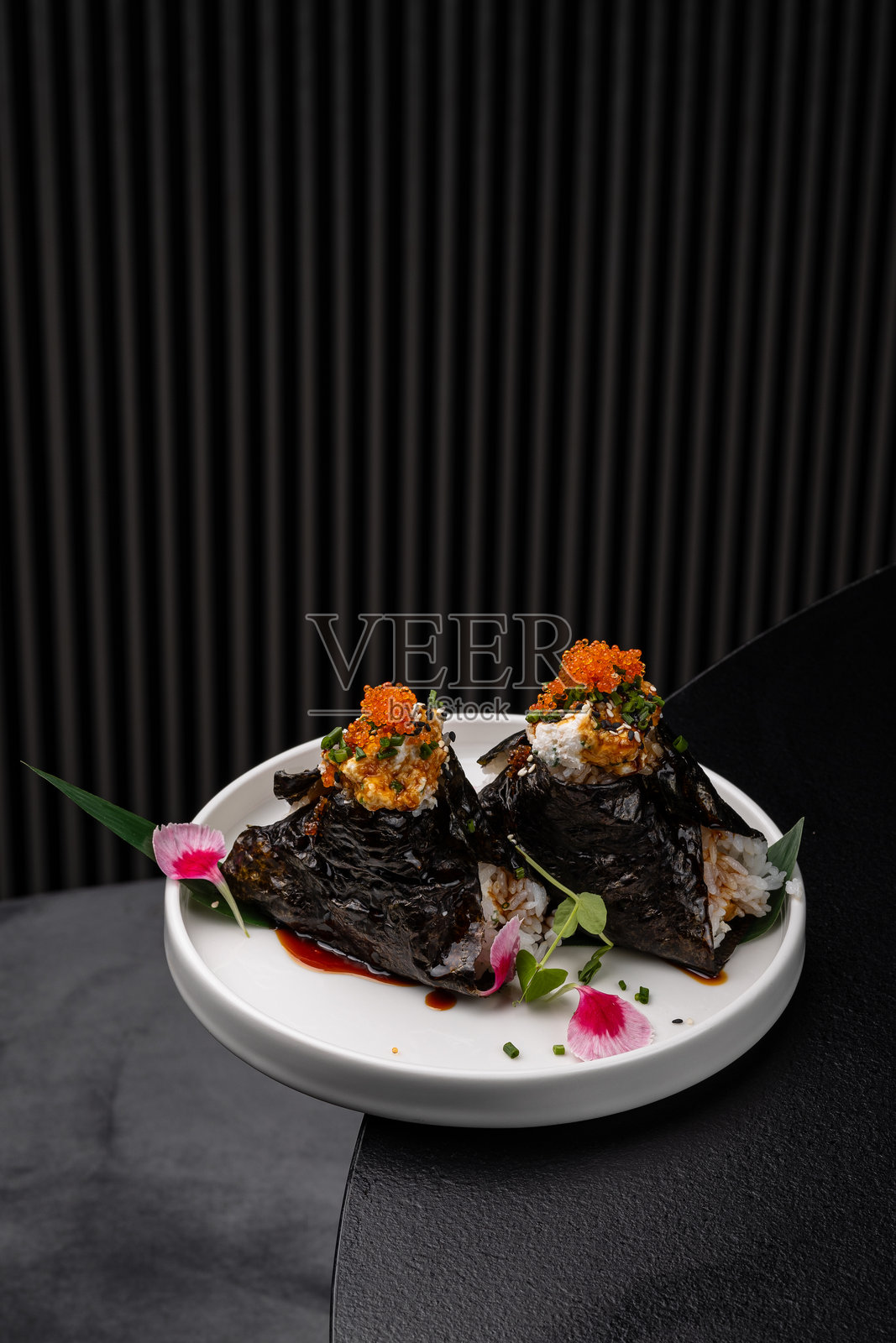 白盘子上放着鱼肉馅饭团，淋上酱汁，适合菜单展示照片摄影图片