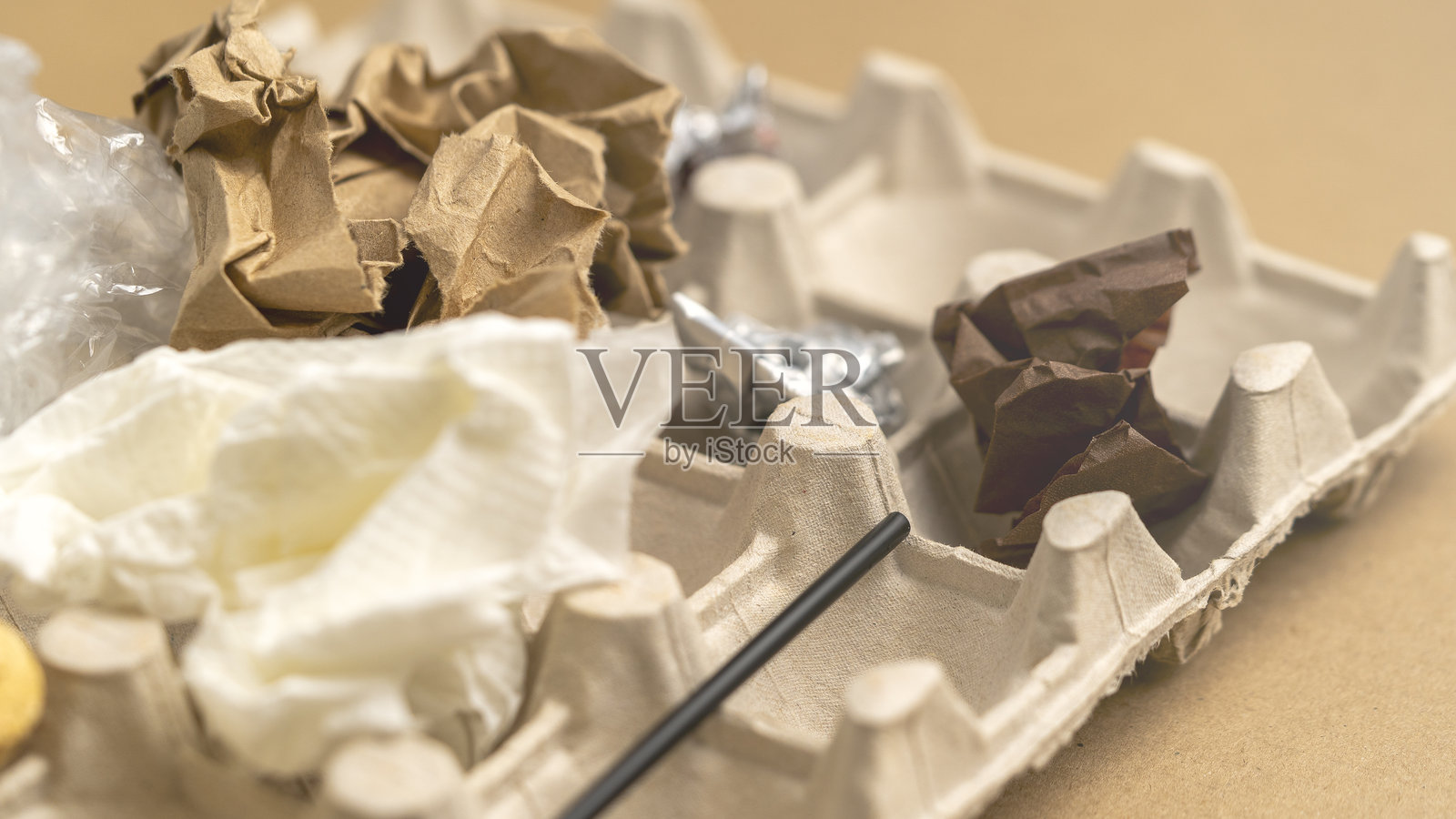 一个装有垃圾的纸板箱，里面有纸和巧克力棒照片摄影图片