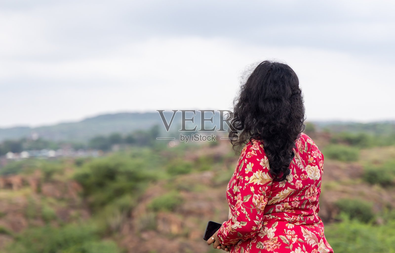 女子在山坡上欣赏自然风光，享受宁静时刻照片摄影图片