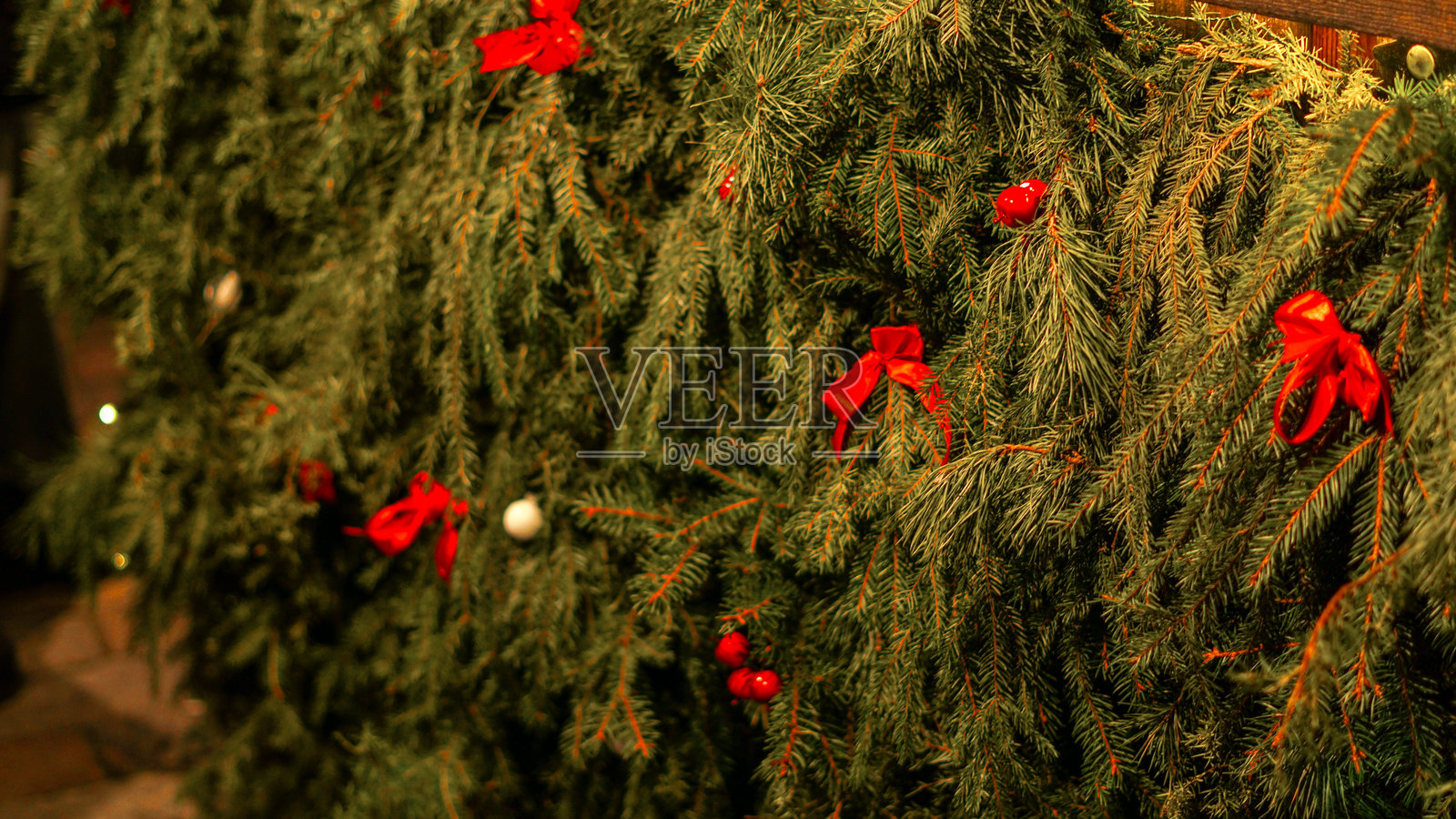 节日圣诞常青树装饰场景，带有红色蝴蝶结和装饰品照片摄影图片