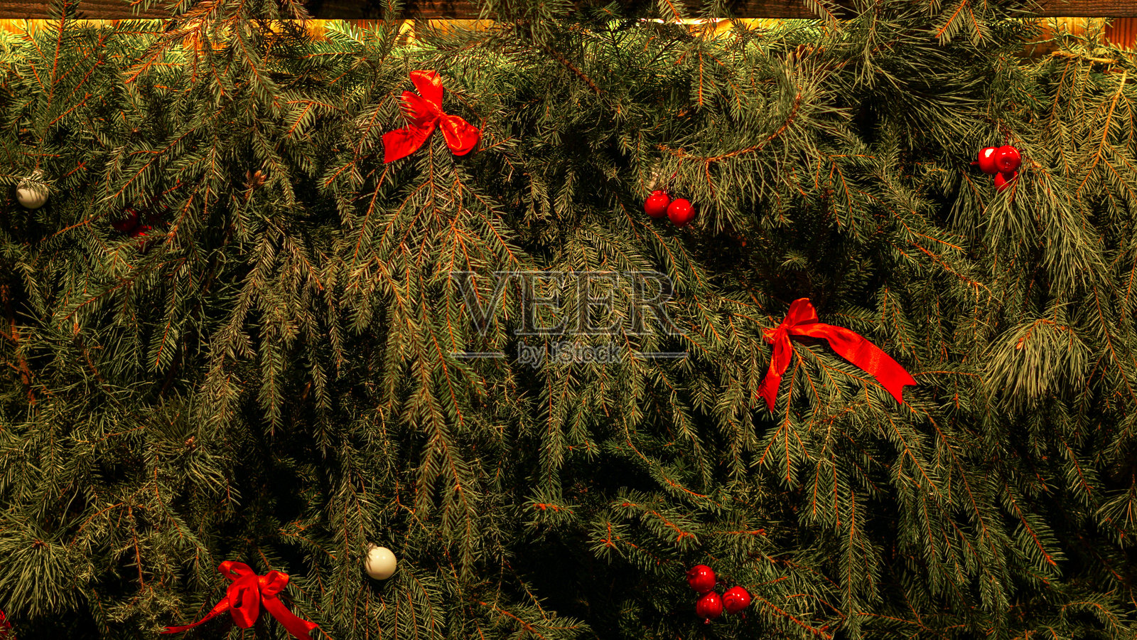 节日装饰的圣诞常青树，配有红色蝴蝶结和装饰品照片摄影图片