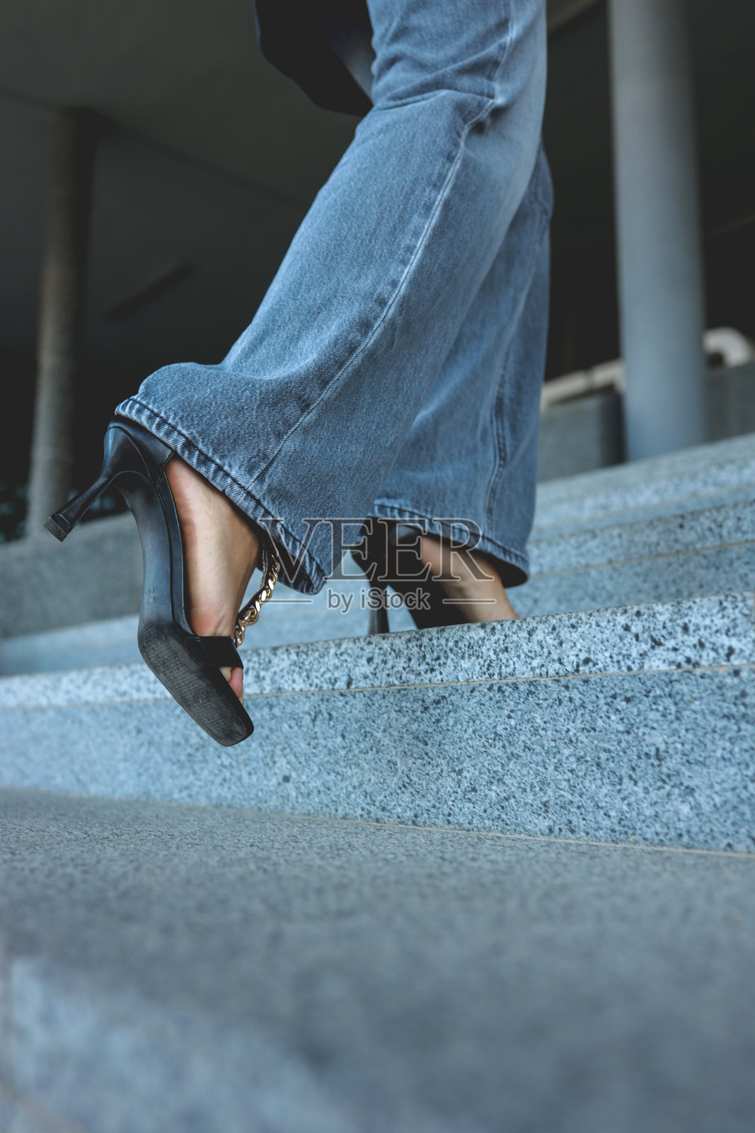 身穿时尚高跟鞋的女性走在户外的石阶上照片摄影图片
