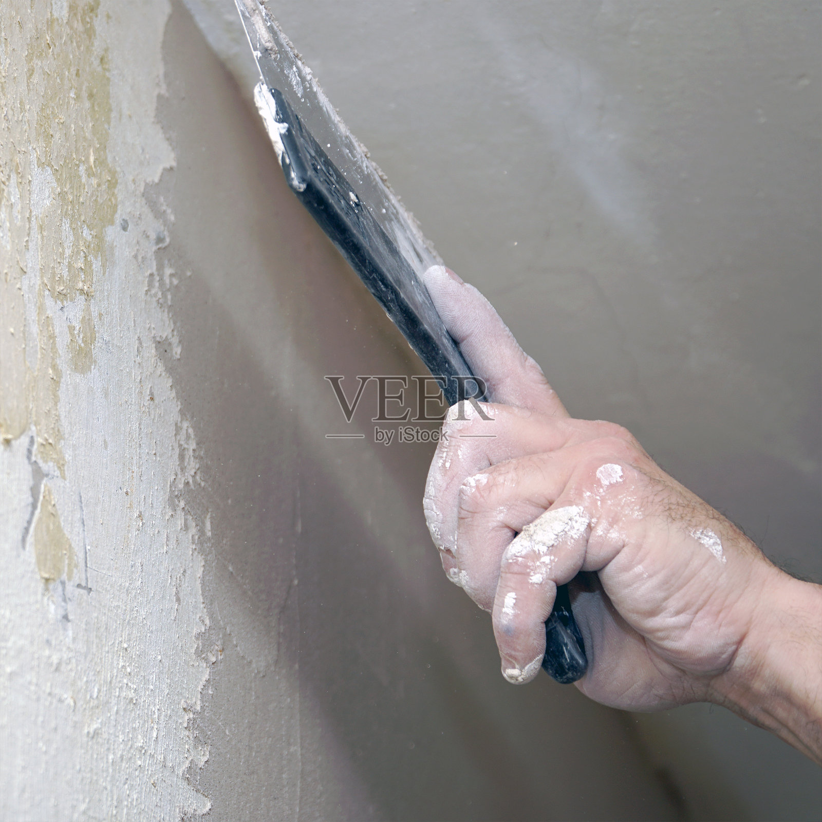 一个男人用抹刀抹墙照片摄影图片