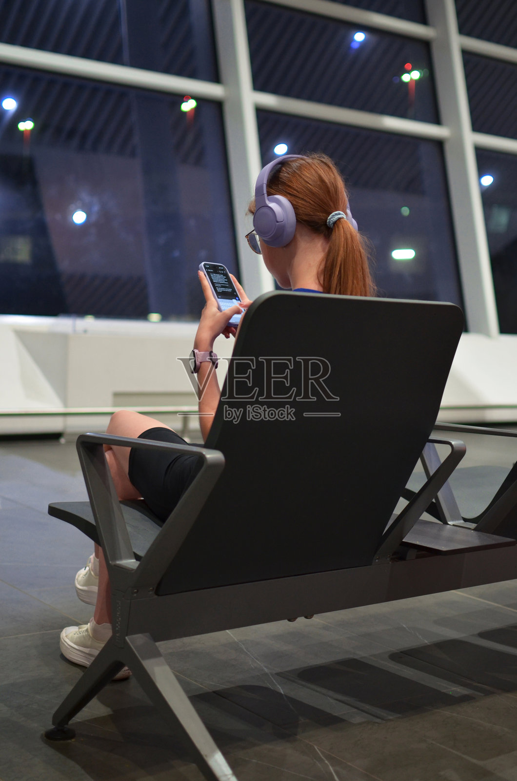 女子在机场候机厅使用手机，正在旅行照片摄影图片