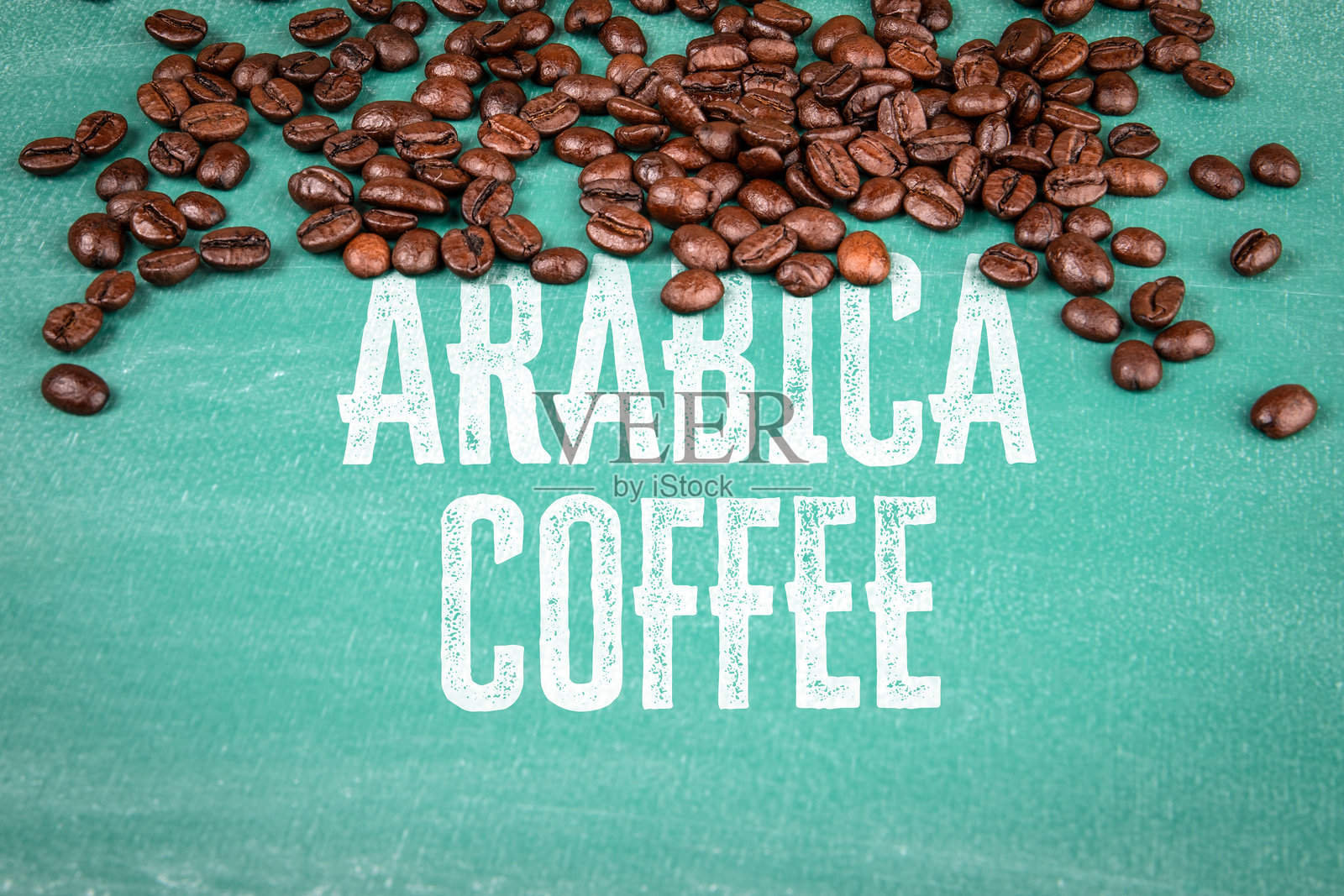 散落在绿色黑板表面上的阿拉比卡咖啡豆照片摄影图片