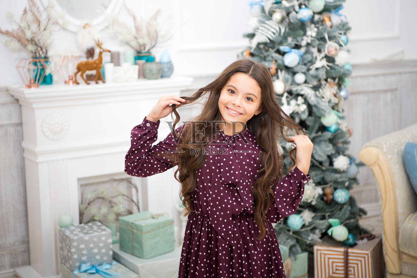 玩耍的可爱小女孩，抱着圣诞礼物，庆祝新年和冬季假期，长发，是圣诞节的送礼时光。照片摄影图片