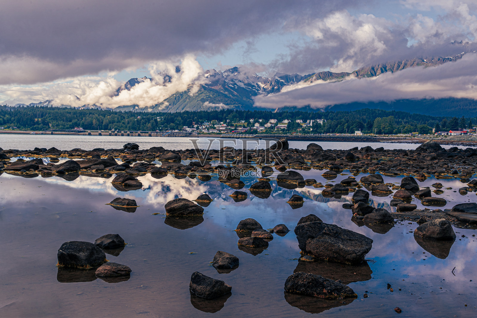 阿拉斯加山脉在城镇附近的潮汐池中倒映照片摄影图片