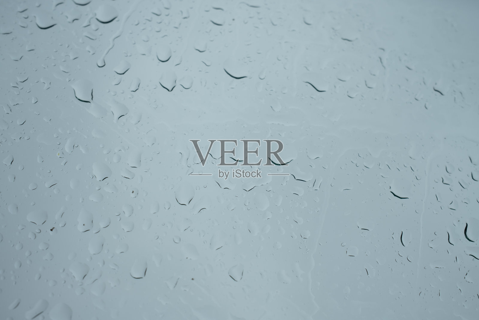 雨滴落在玻璃上，抽象的纹理背景。照片摄影图片