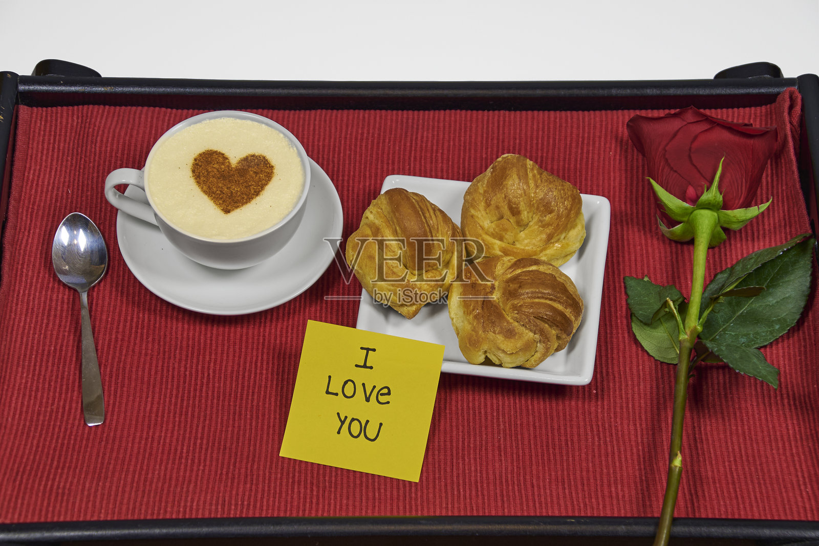 床上的早餐，托盘里有咖啡加牛奶和羊角面包照片摄影图片