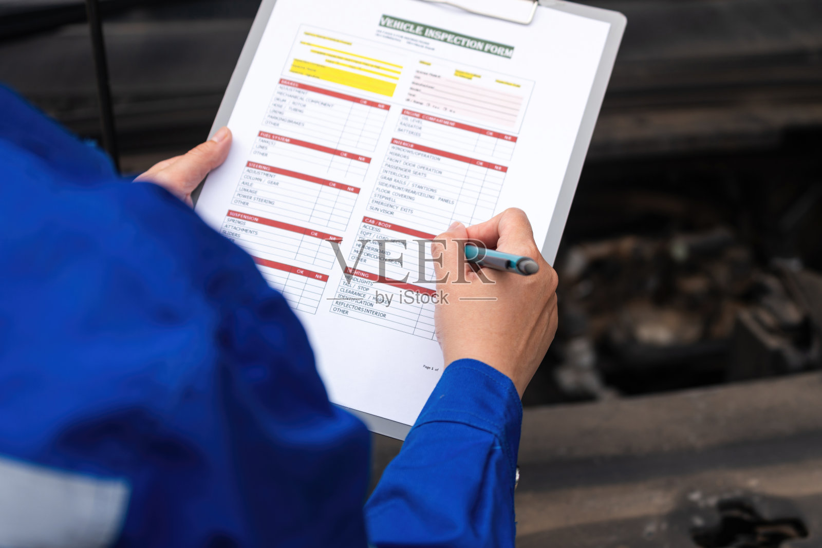 汽车维修技师正在检查车辆，并核对检查清单表格照片摄影图片