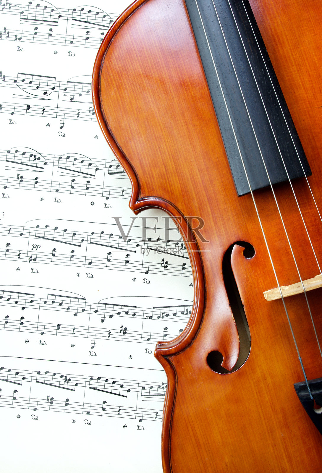小提琴在乐谱背景前，特写照片摄影图片