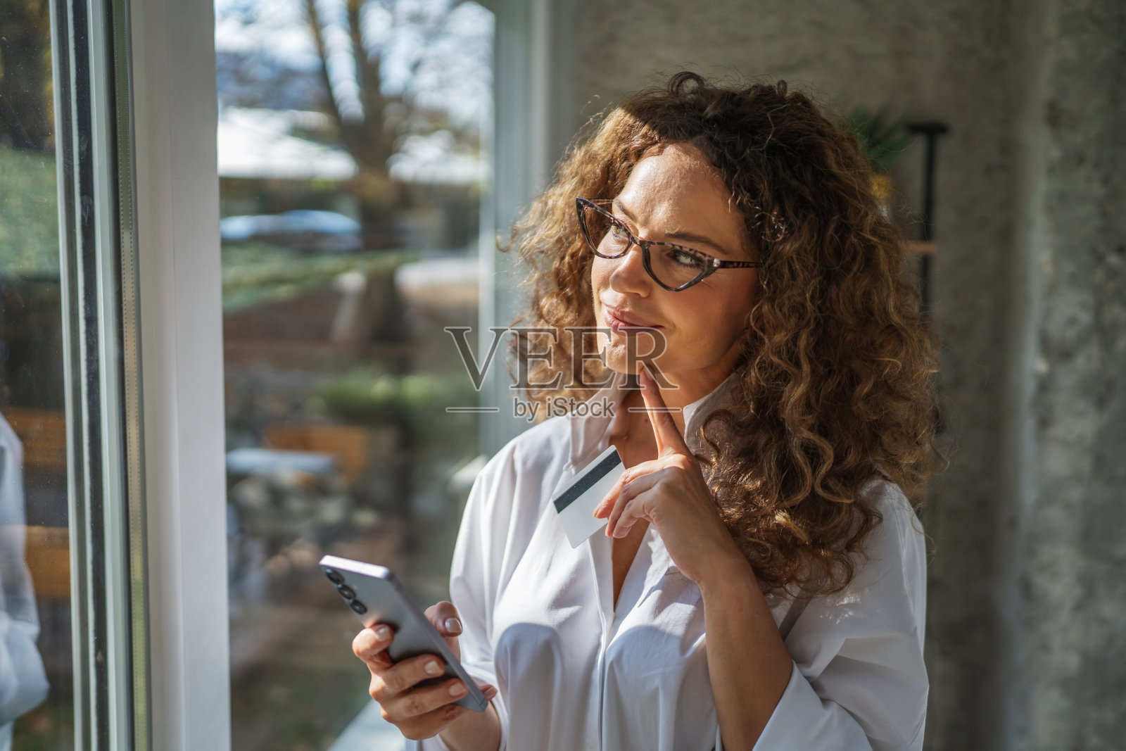 女子使用智能手机和信用卡进行在线支付照片摄影图片