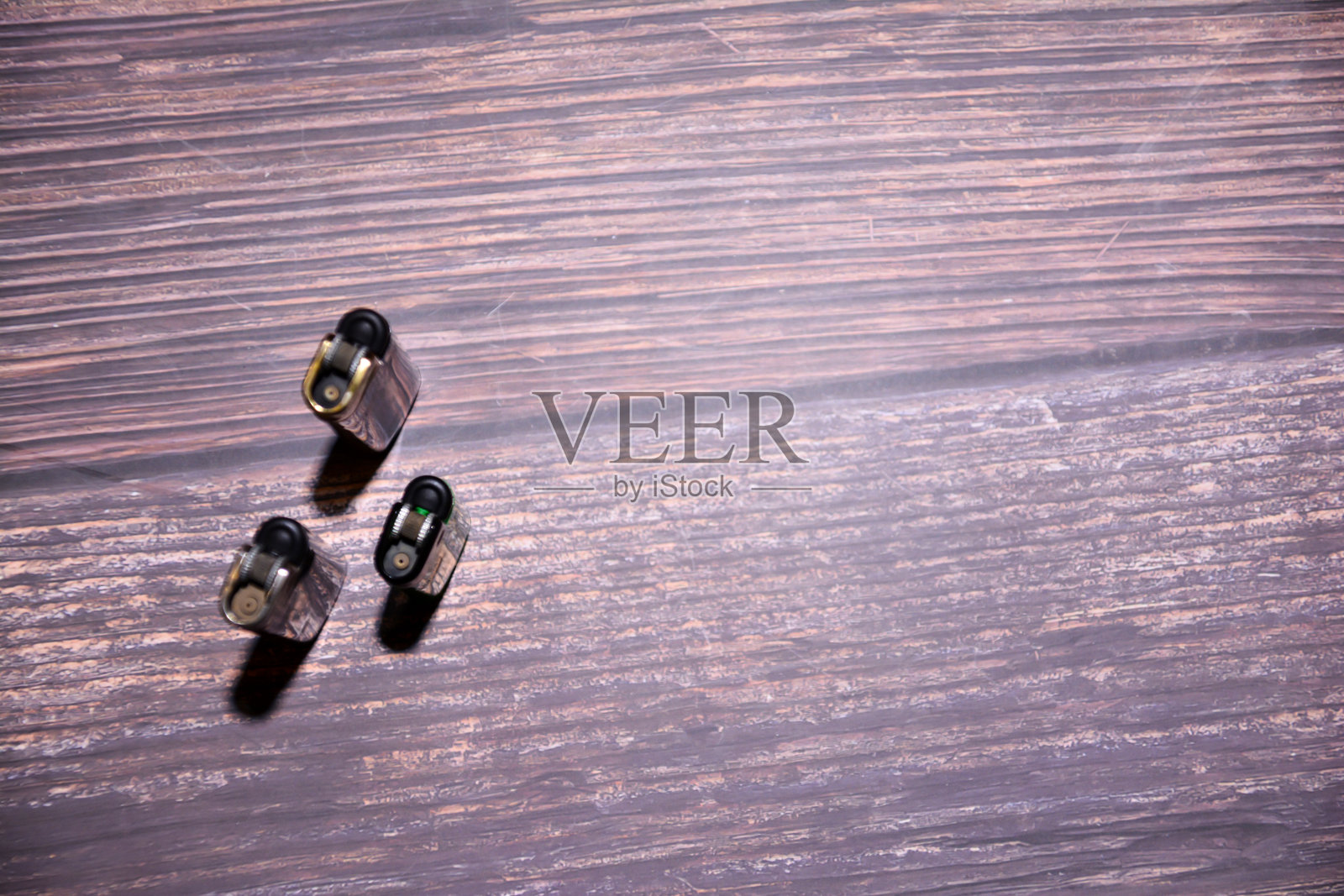 木质背景上的打火机。俯视。桌子上的打火机。用于香烟的火。照片摄影图片