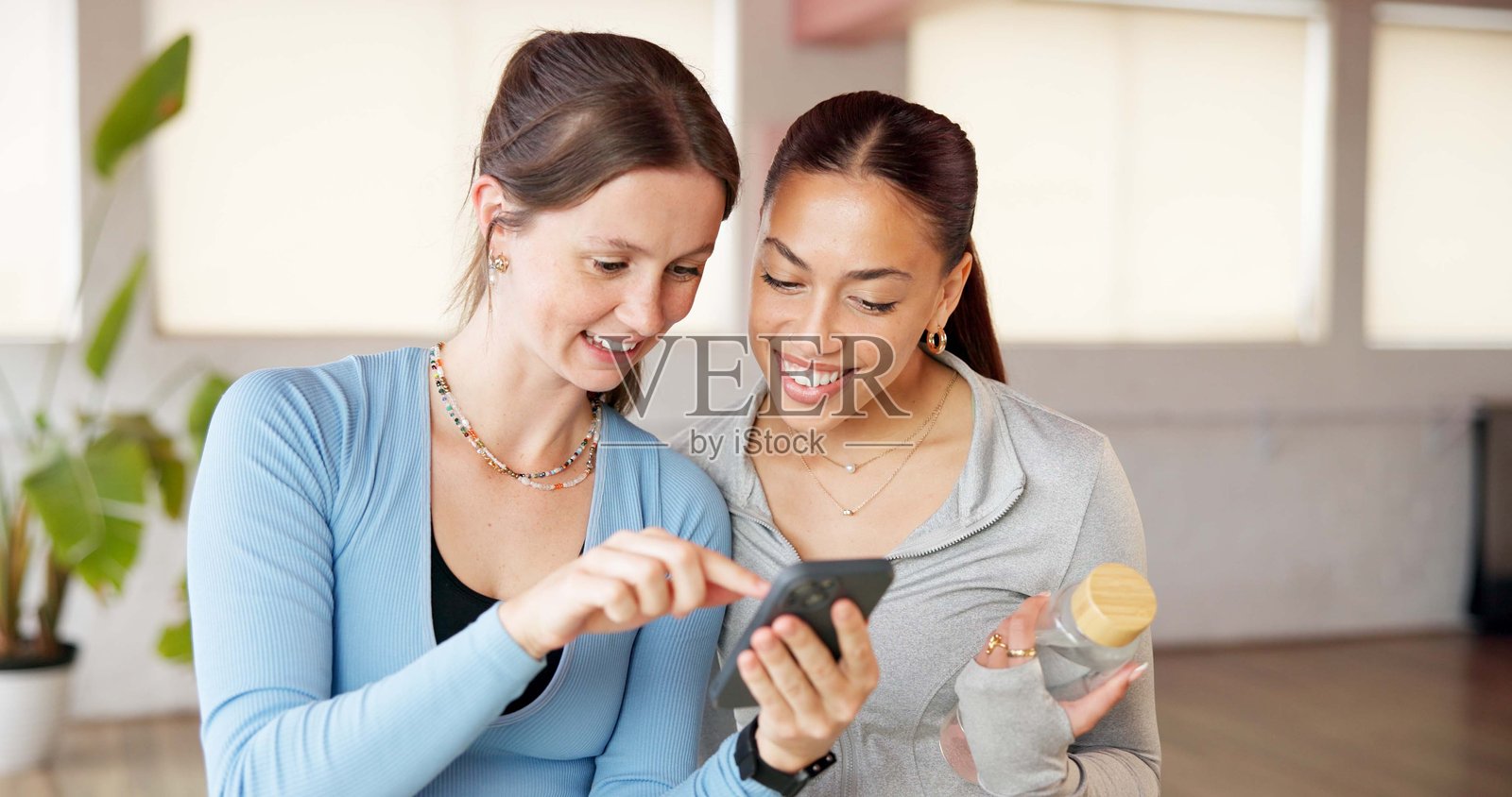 手机、普拉提和与朋友们在工作室阅读，用于社交媒体、锻炼帖子和评论。线上瑜伽讨论、沟通应用和与课堂上的女性聊天，用于健康、养生和支持。照片摄影图片