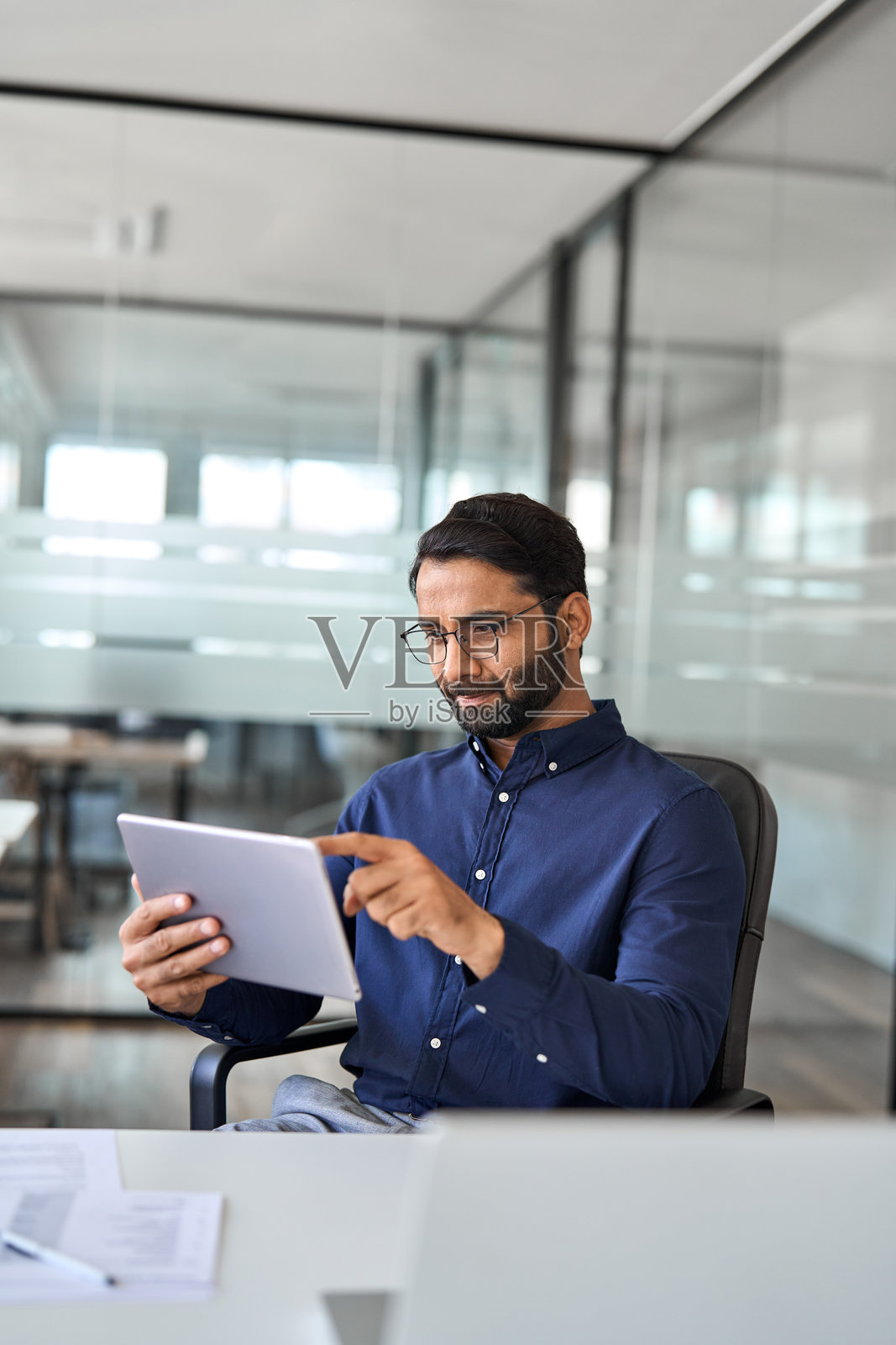 忙碌的印度商人、高管、经理在办公室使用平板电脑。照片摄影图片