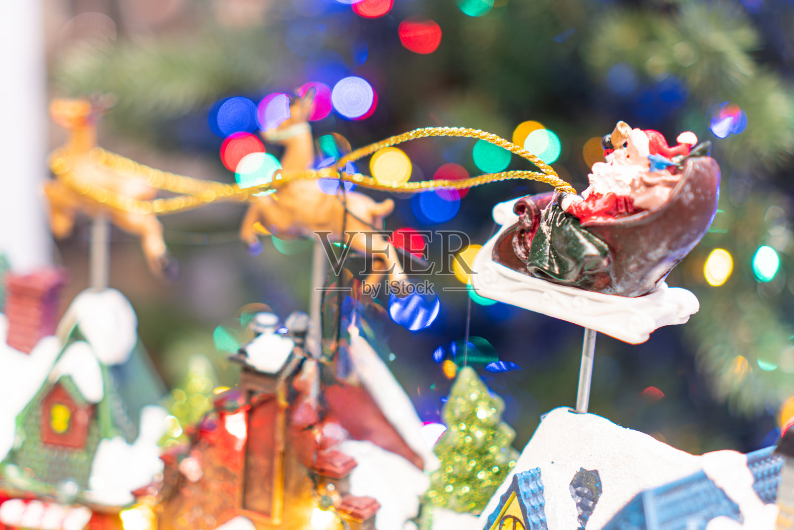 中心位置的圣诞树，装饰着五颜六色的彩灯和各种装饰品，包括巨大的巧克力圣诞老人和驯鹿造型玩偶。整个场景充满了节日气氛，适合圣诞节。照片摄影图片