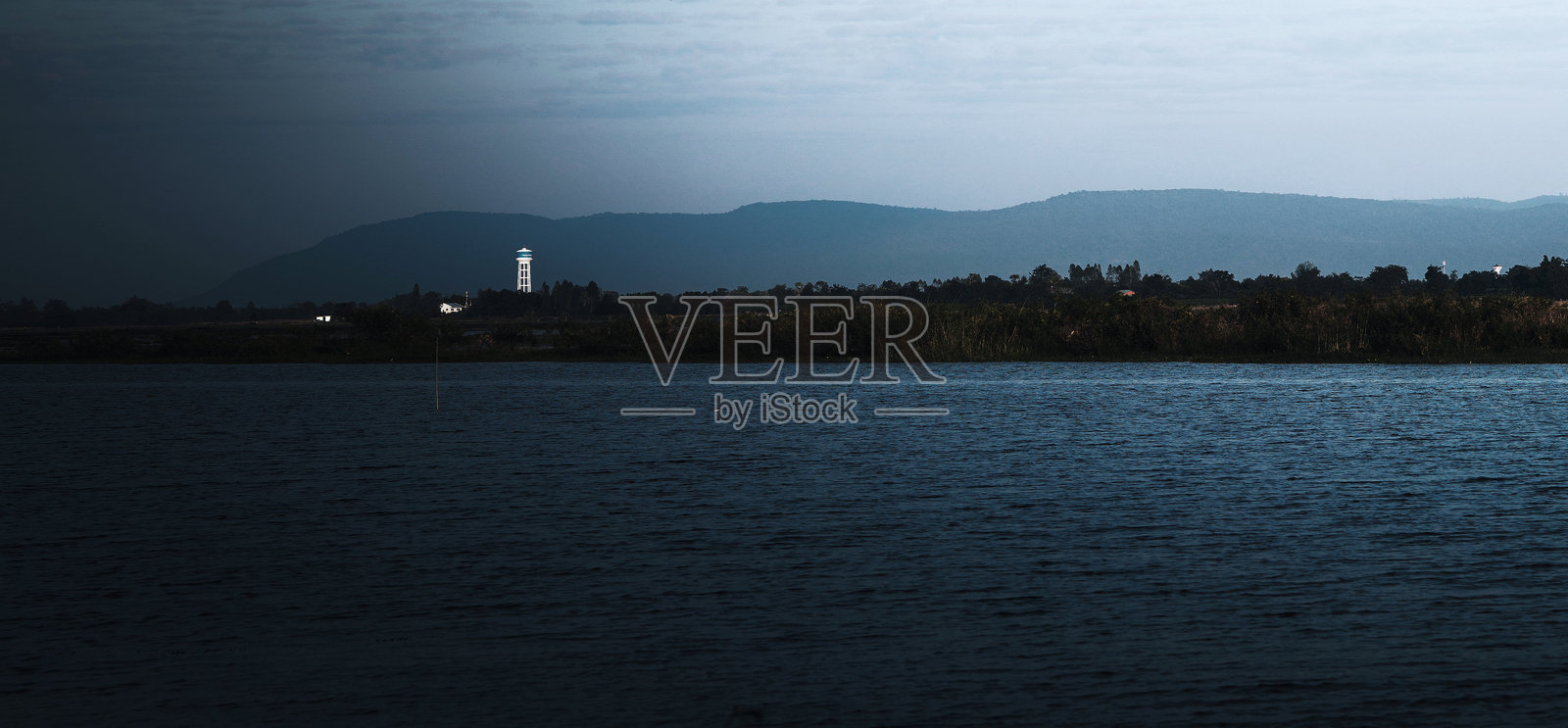 远处有灯塔的大片水域照片摄影图片