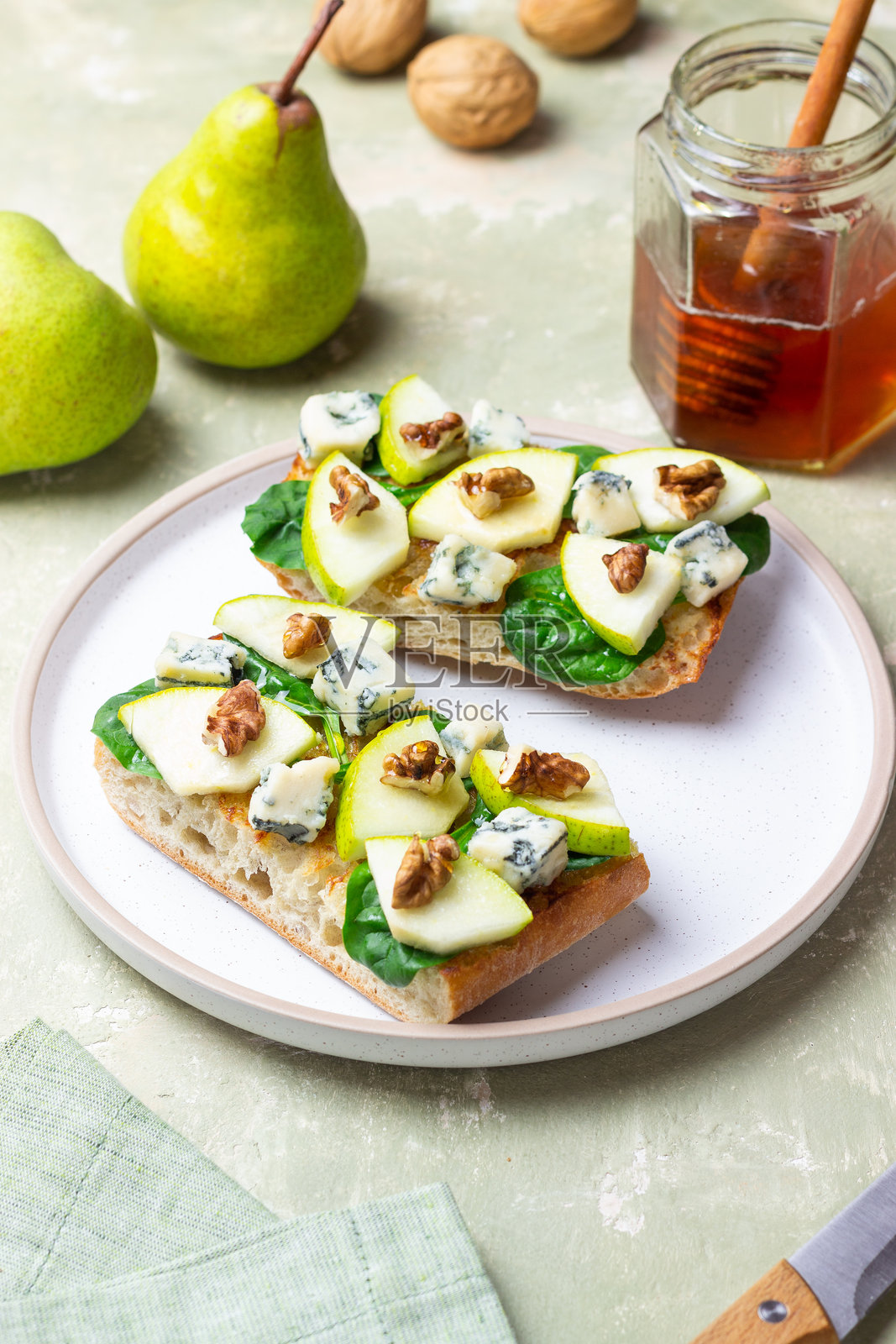 菠菜、蜂蜜、蓝纹奶酪、梨和坚果的布鲁斯凯塔。健康饮食。素食。照片摄影图片