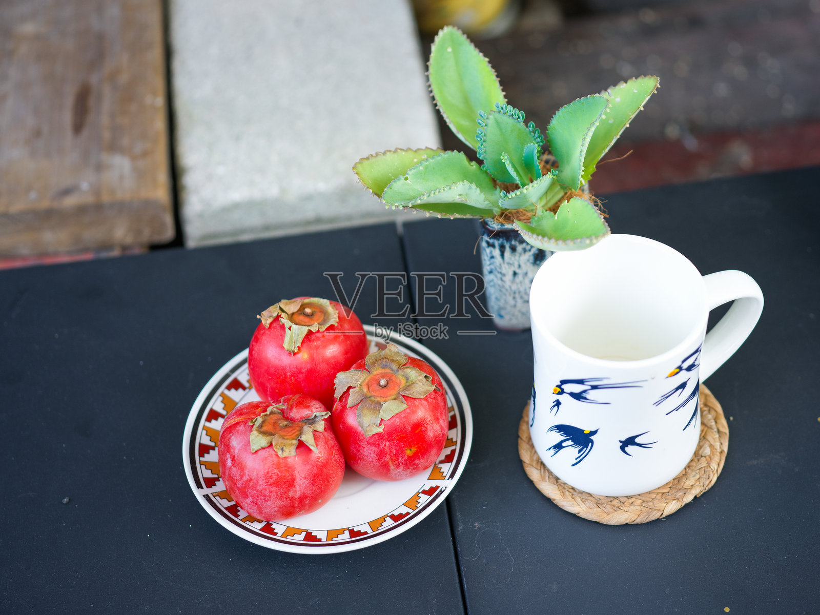 桌上柿子、装饰茶杯与小盆栽的静物摆设照片摄影图片