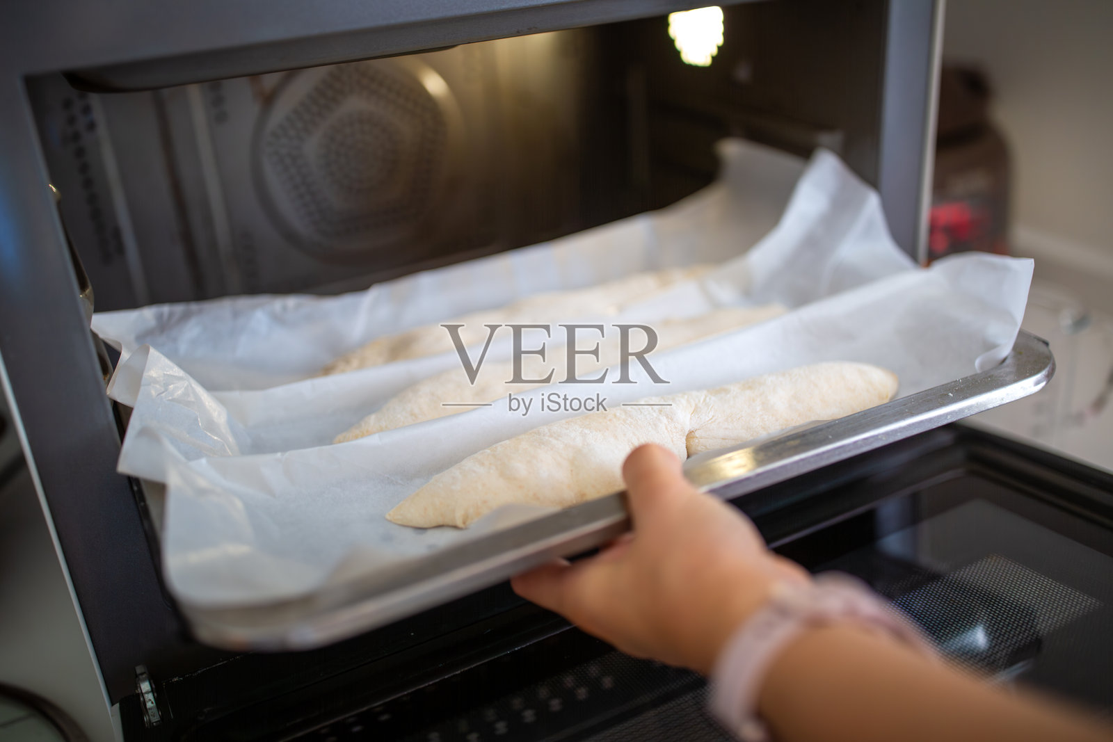 将生面团放入烤箱烘烤照片摄影图片