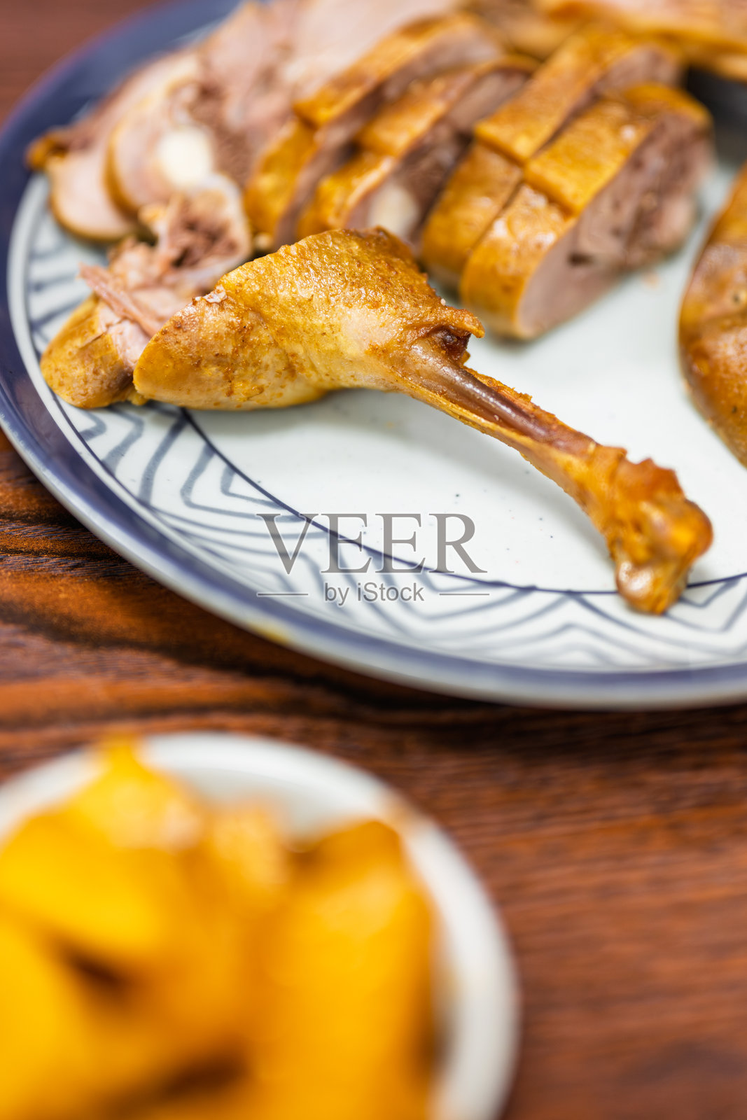 精致盘中盛放的烤鸭片，皮脆肉嫩照片摄影图片