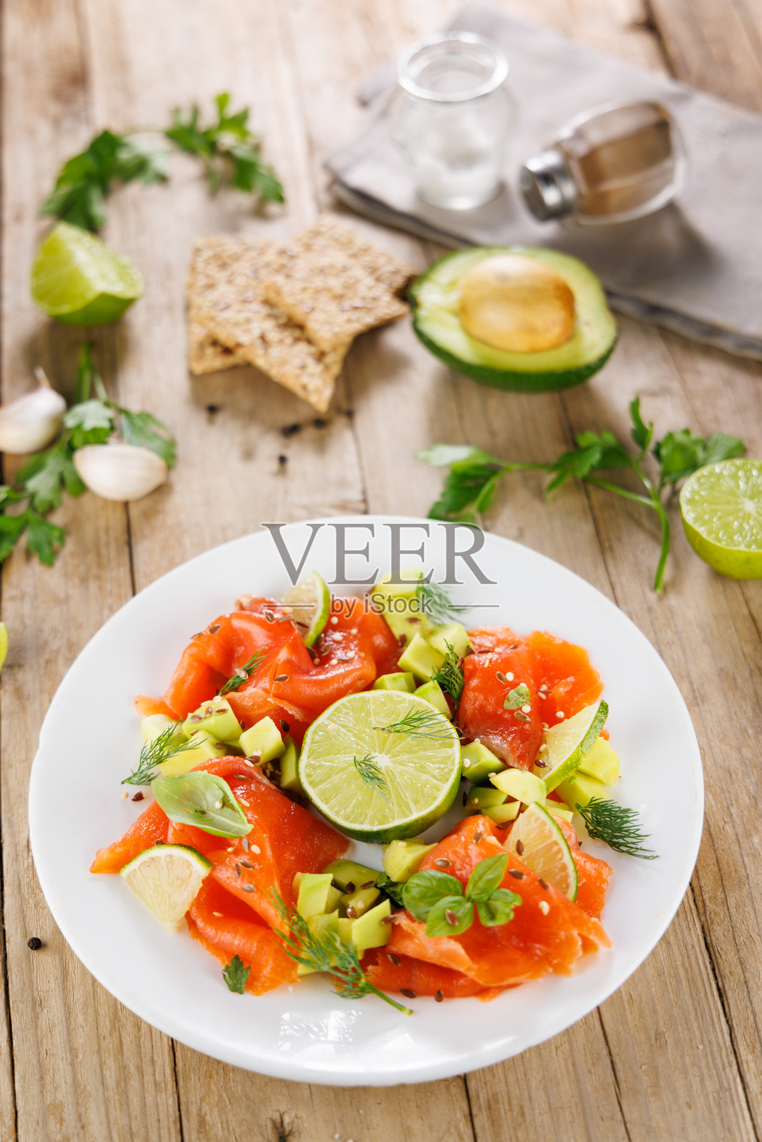 烟熏三文鱼、牛油果和新鲜香草。节日餐盘沙拉照片摄影图片