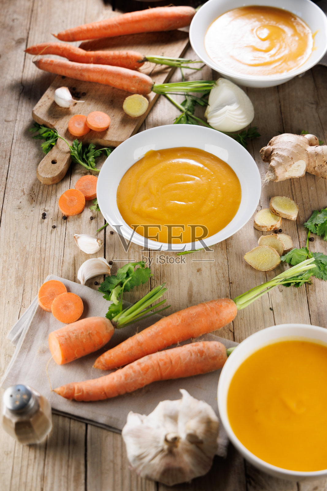 木板上的食材和碗里的蔬菜汤照片摄影图片