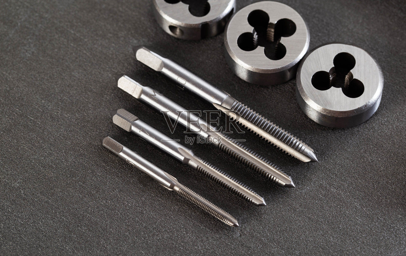 用于在各种材料上创建螺纹的金属丝锥和板牙套装，用于工程和机械加工应用的精密工具，专业设备照片摄影图片