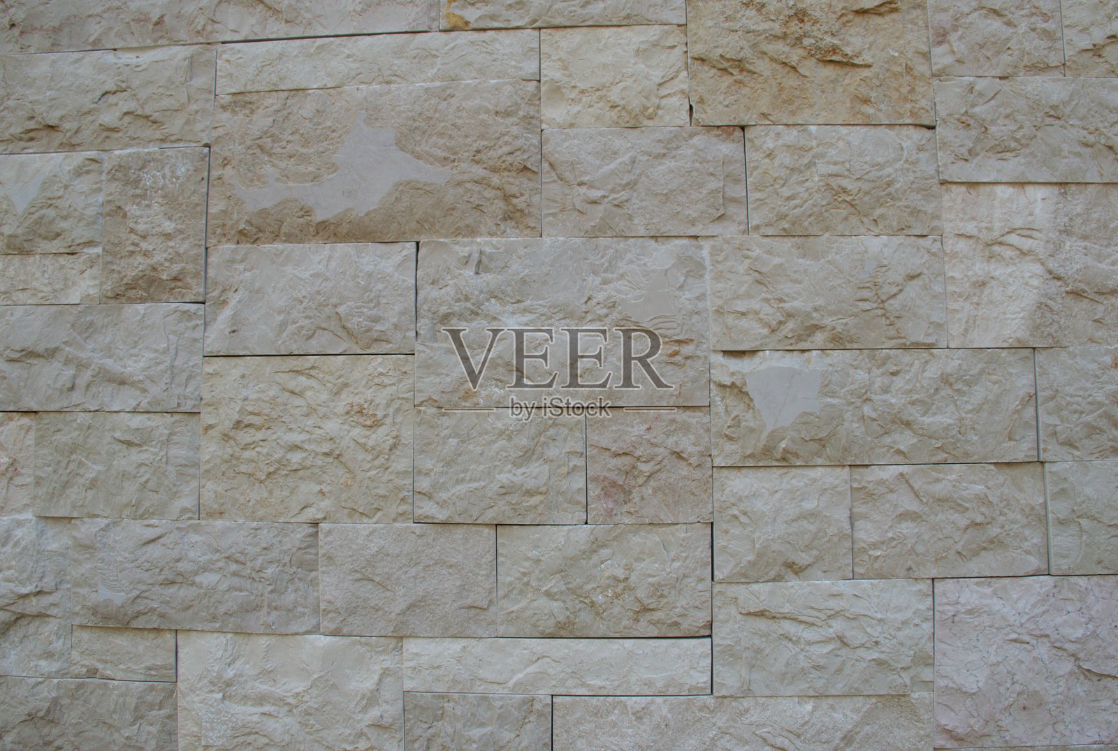 具有粗糙、坚硬表面和建筑图案的天然米色石墙照片摄影图片