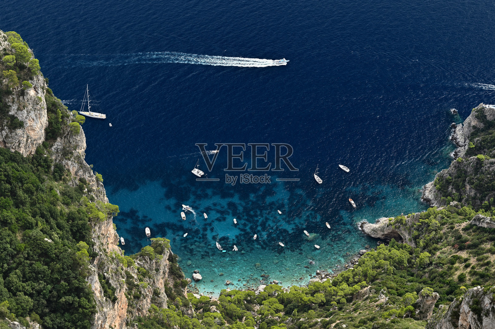 卡普里岛小海港附近停泊的船只，蒙特索拉罗山鸟瞰图。意大利那不勒斯照片摄影图片