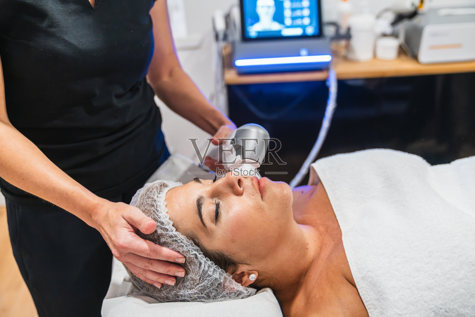 美容诊所里，一位女士正在接受高强度聚焦超声（HIFU）面部美容治疗照片摄影图片