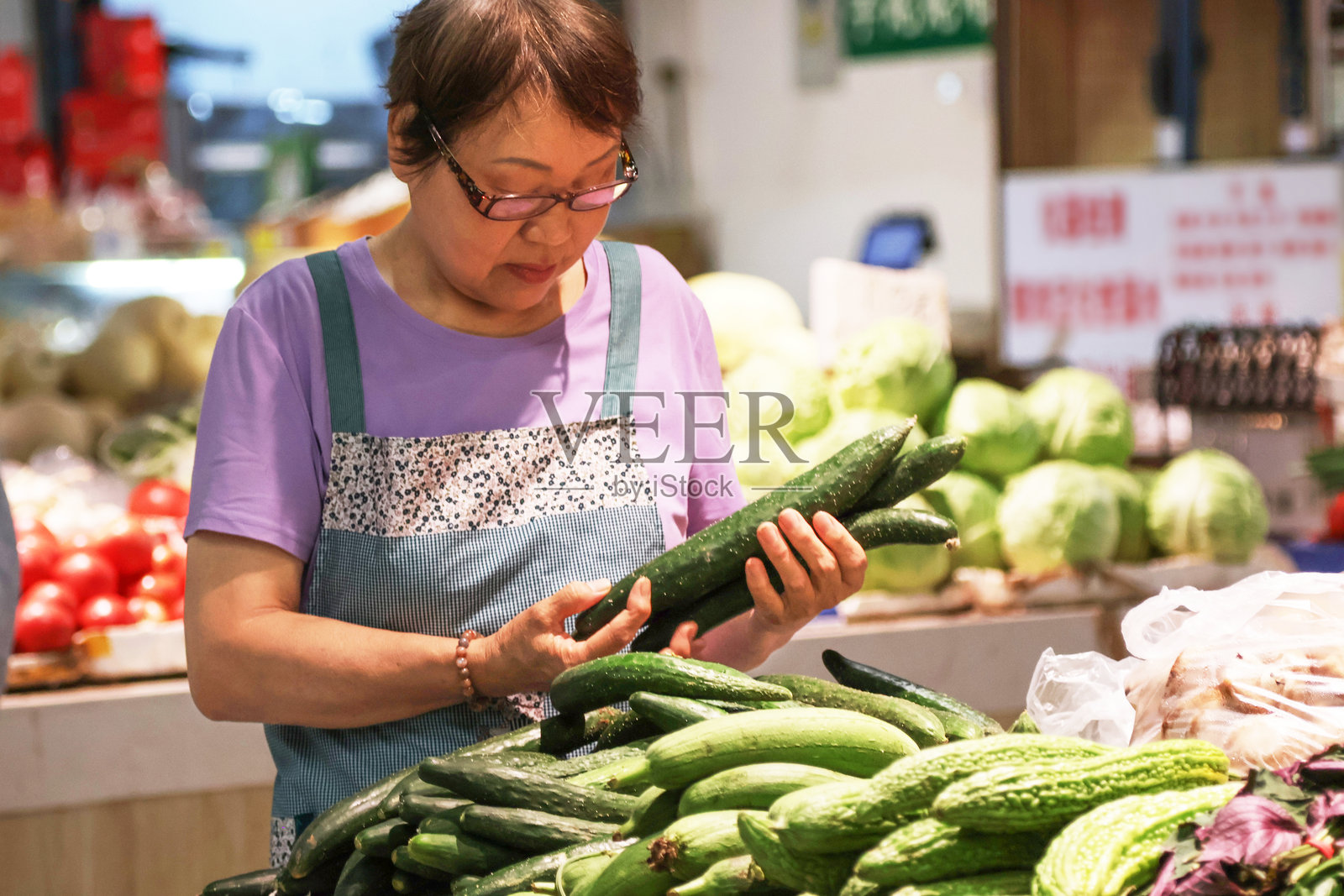 老年亚洲女性在农贸市场摊位前照片摄影图片