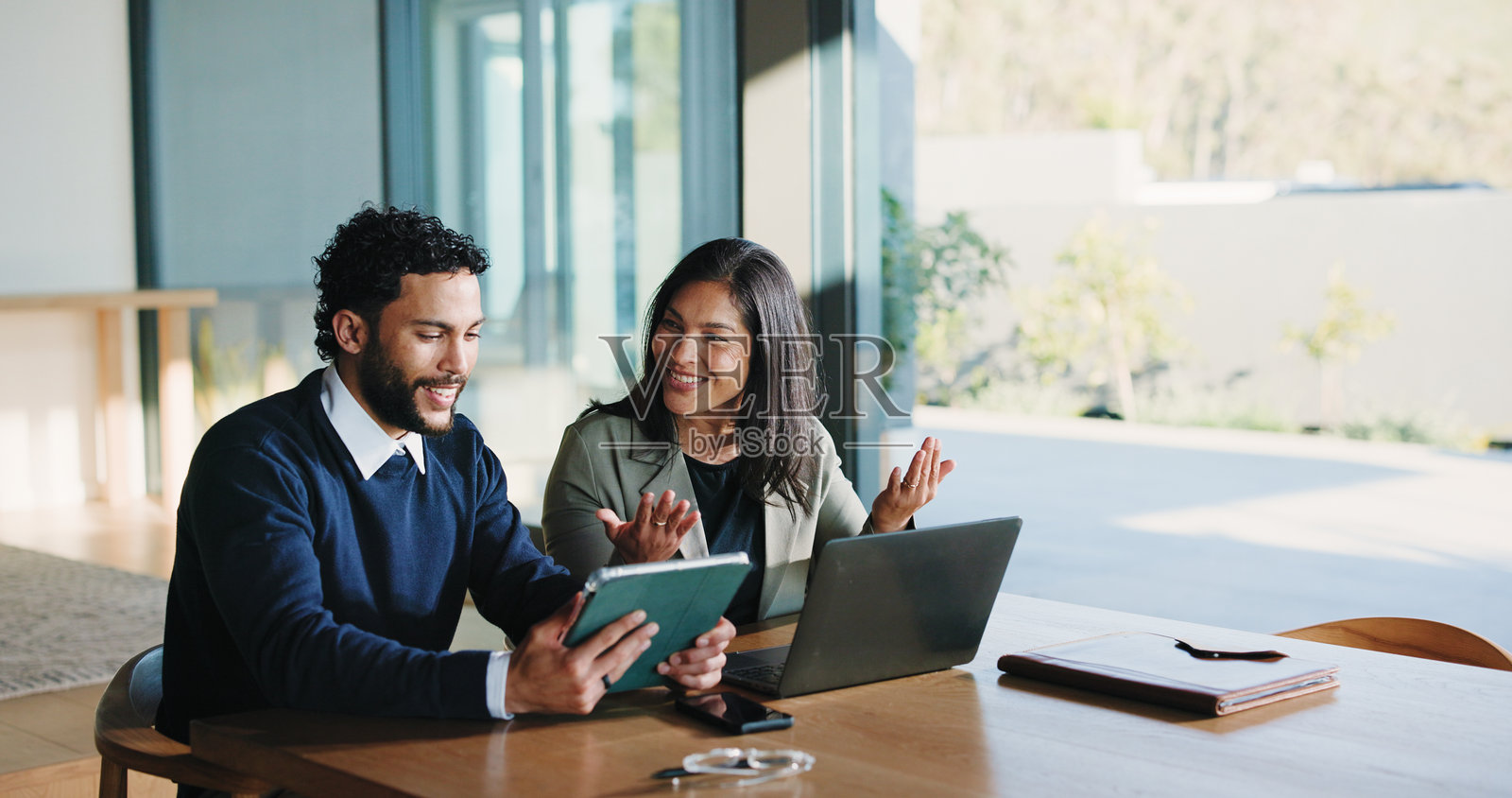 快乐的团队，商务人士在会议中讨论技术、金融解决方案或反馈。使用笔记本电脑、平板电脑在办公室讨论投资创意、提案和公司项目成功。照片摄影图片