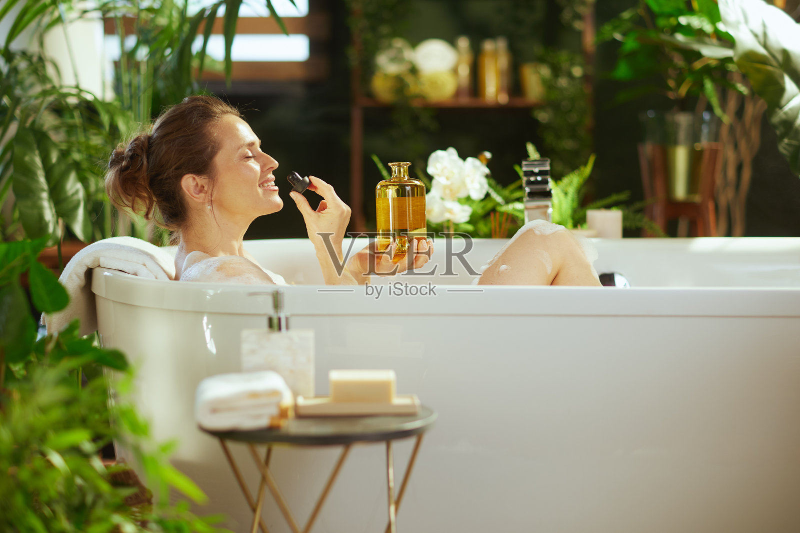 女性在放松沐浴时使用芳香疗法精油照片摄影图片