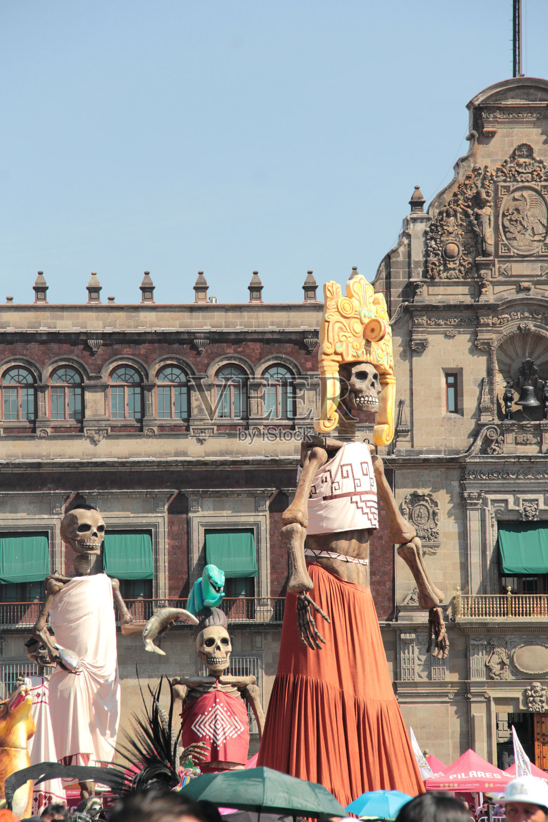 墨西哥城索卡洛广场上宏伟的亡灵节祭品，有骷髅、人形和犬类骨骼的塑像，以及万寿菊花照片摄影图片