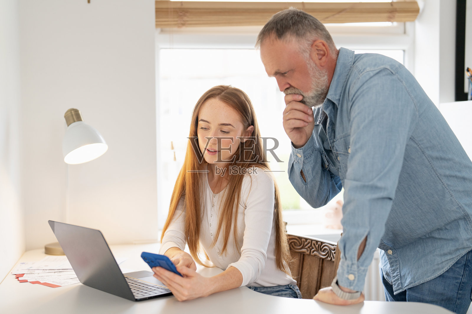 白天，两个人一起在办公桌上合作一个项目，讨论着想法。照片摄影图片