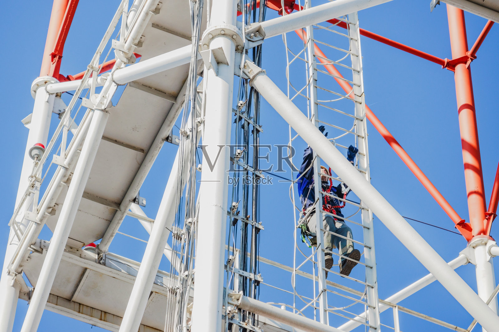 晴朗天气下，工人正在攀爬通讯塔照片摄影图片
