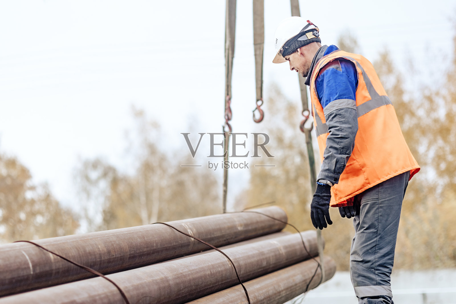 建筑工人户外搬运沉重钢管照片摄影图片