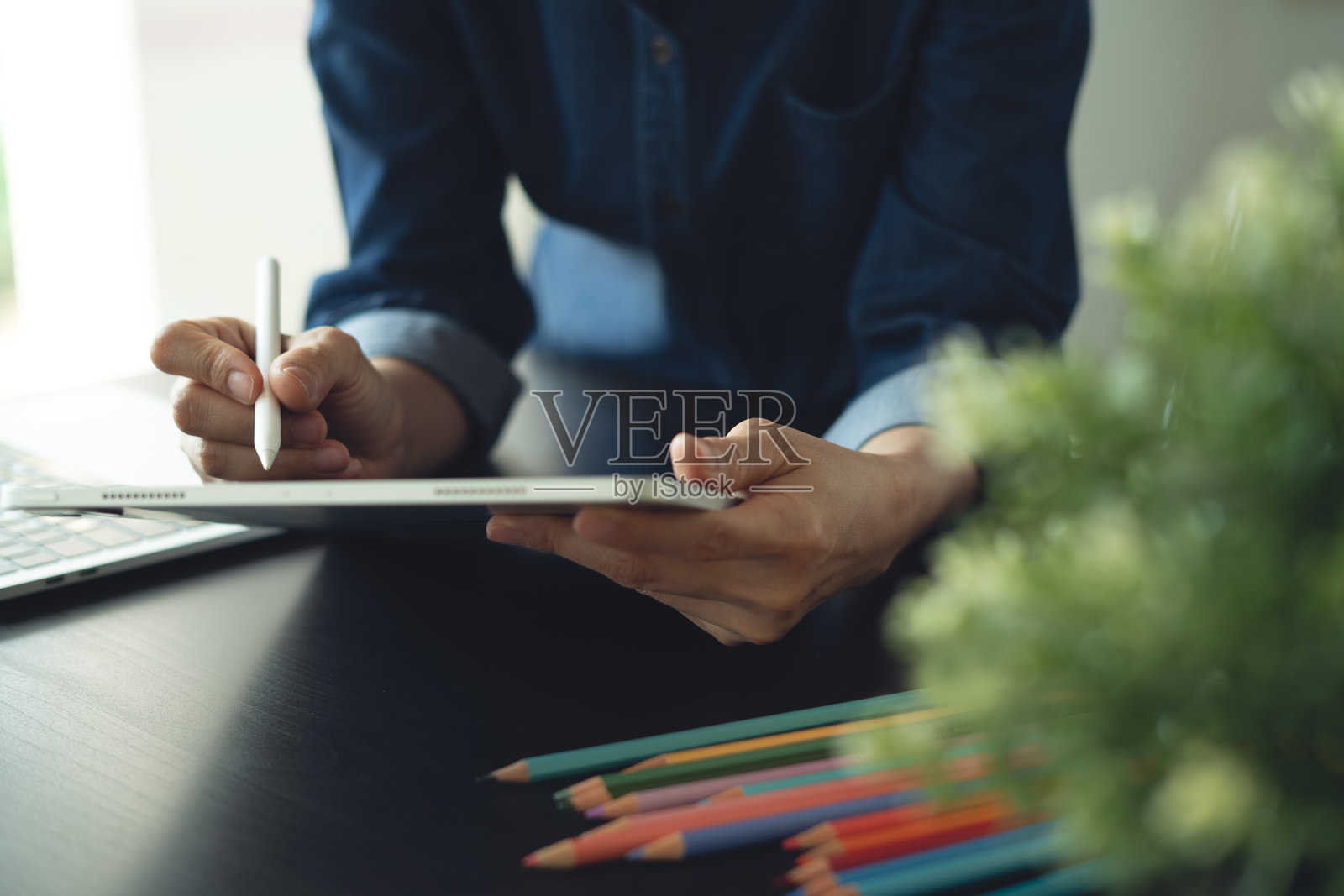 建筑与室内设计概念。一位亚洲女商人建筑师正在工作室使用数字平板电脑创建室内设计项目。一位自由职业者女性正在办公室工作，特写照片摄影图片