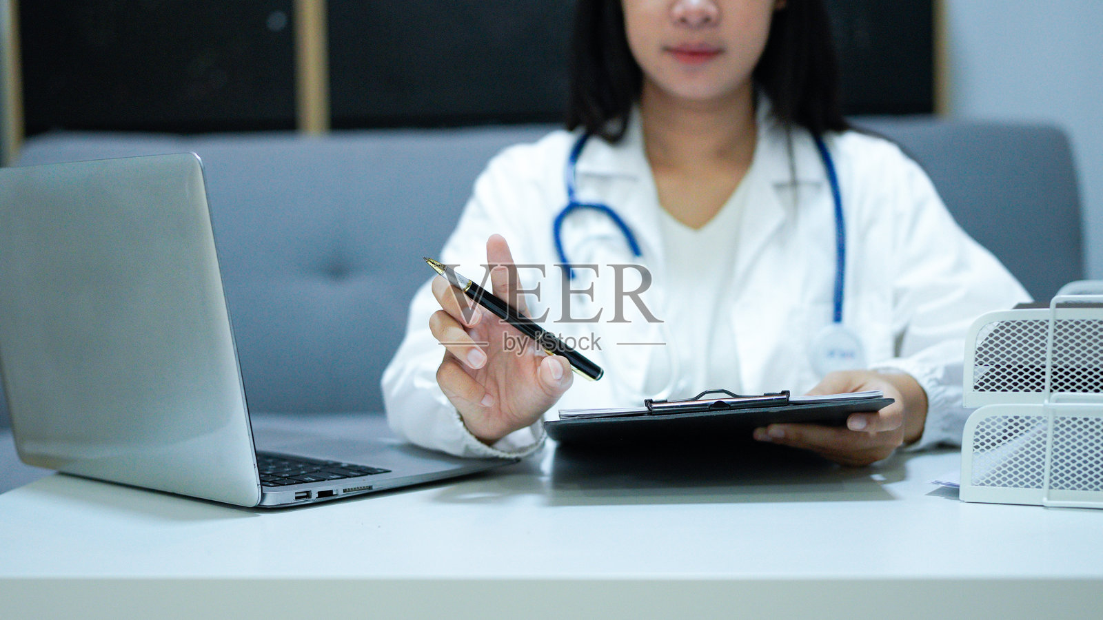 医护人员医生在病历夹上书写病历。工作中的女性医生，身份不可辨认。医学与药学照片摄影图片
