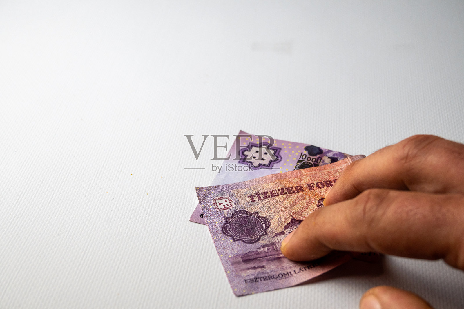 张开的手部分遮挡着一万英尺的钞票照片摄影图片