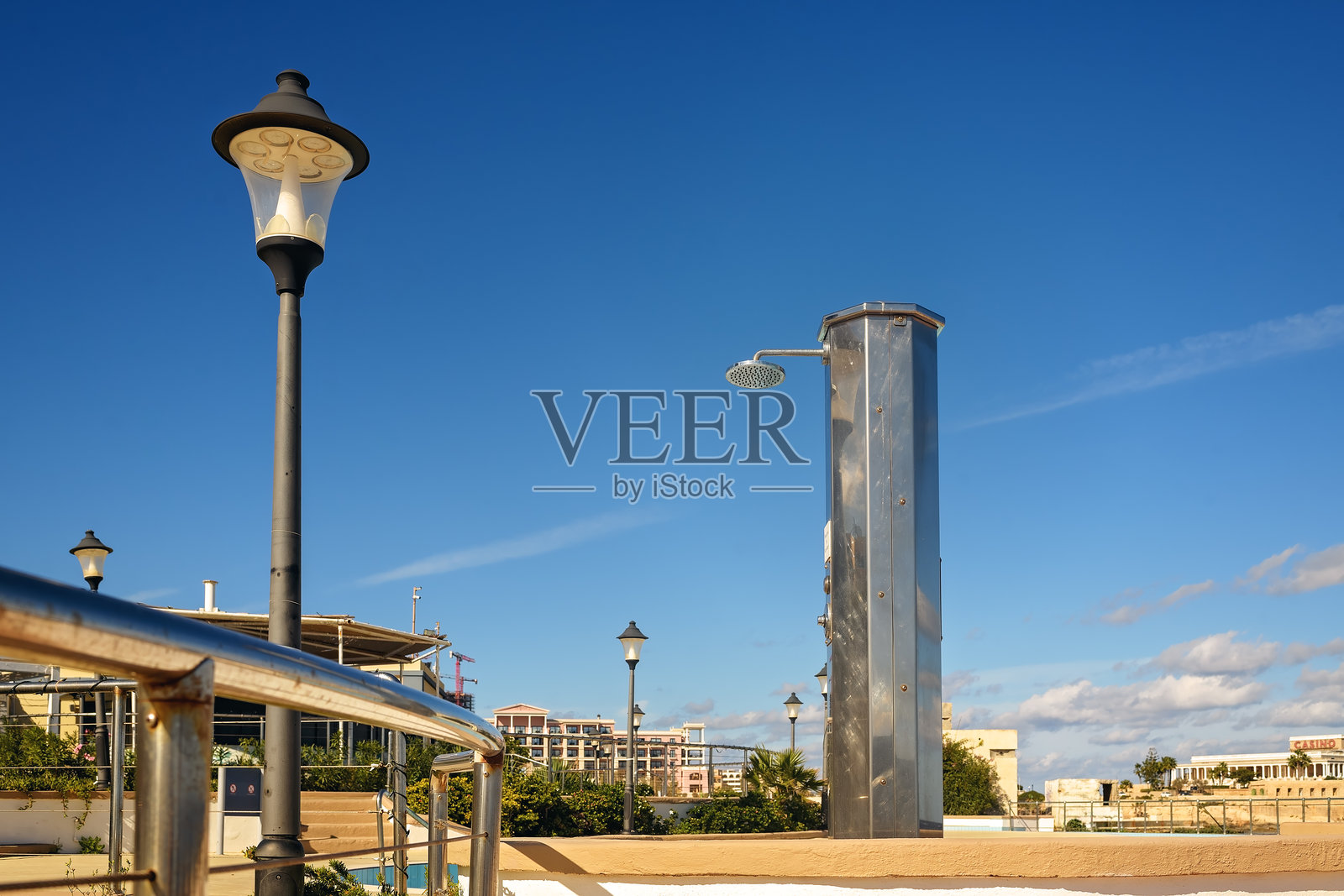 阳光明媚的度假村露台上，公共淋浴间和户外灯柱。照片摄影图片