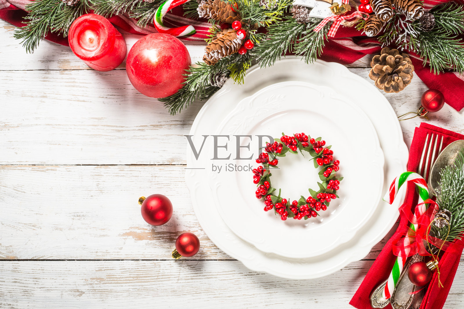 圣诞节餐桌布置，白色木桌上摆放着节日装饰。照片摄影图片