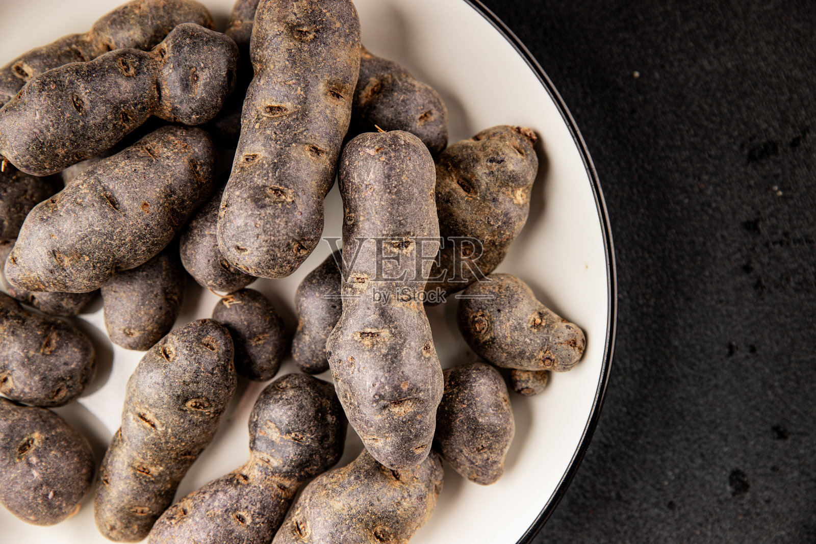 紫薯生食蓝紫色蔬菜新鲜美食背景置于餐桌上，乡村风格美食俯视视角，留有复制空间，适合生酮和旧石器饮食，素食友好照片摄影图片